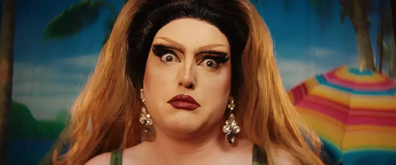 Holiday: a drag performer with a towering wig and dramatic make-up stares wide-eyed at the camera