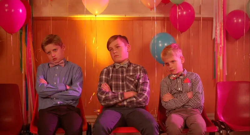 Mrs McCutcheon: three boys in bow ties sit with arms folded at a school dance