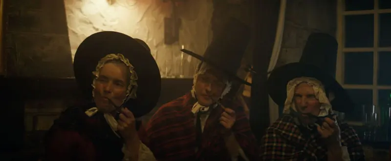 Never Never Never: three people in traditional Welsh hats and shawls in a candlelit room