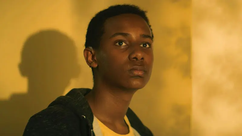 Tarneit: a teenage boy in a hoodie lit by warm sunlight against a yellow wall