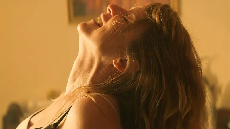 Tarneit: a woman tilts her head back in a dim, warmly lit room